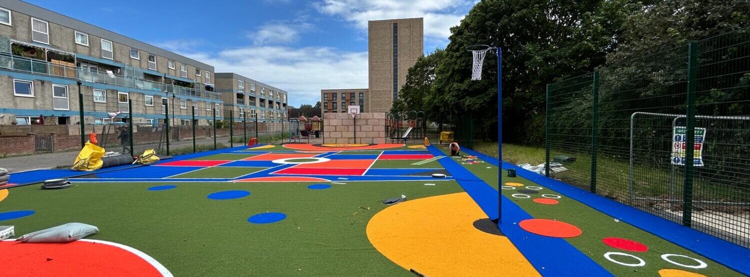 a colourful green, blue and red and yellow play zone with basketball hoops in Portsmouth