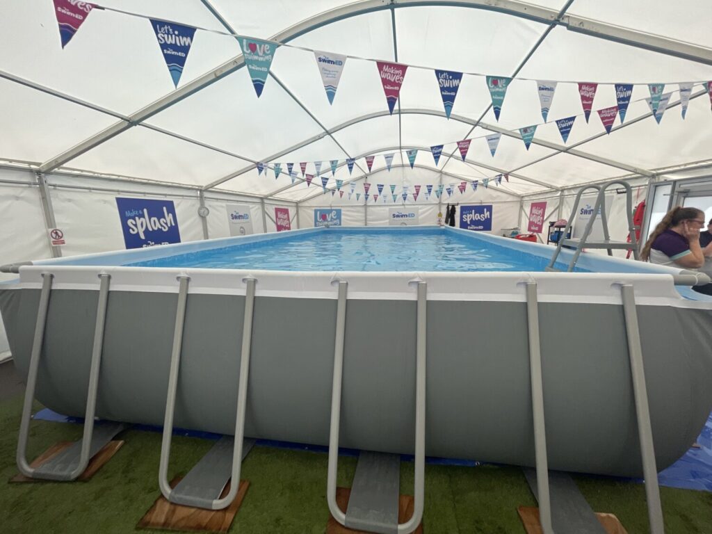 The inside of the marquee, the pool with bunting hanging from the ceiling